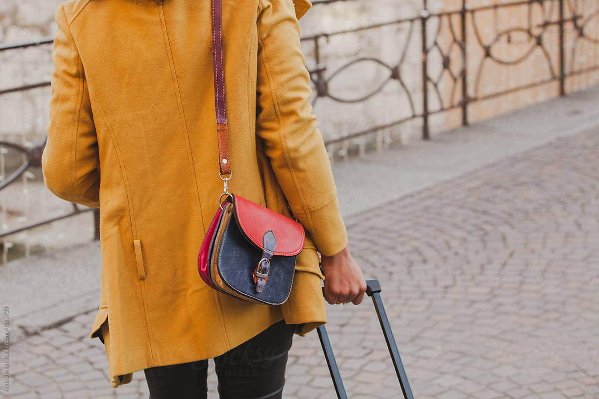 woman in yellow coat with red handbag, autumn