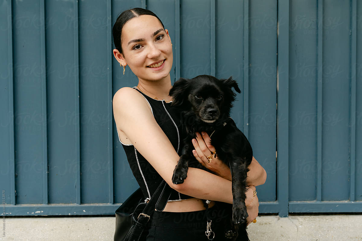 portrait of happy stylish woman in the street with her dog