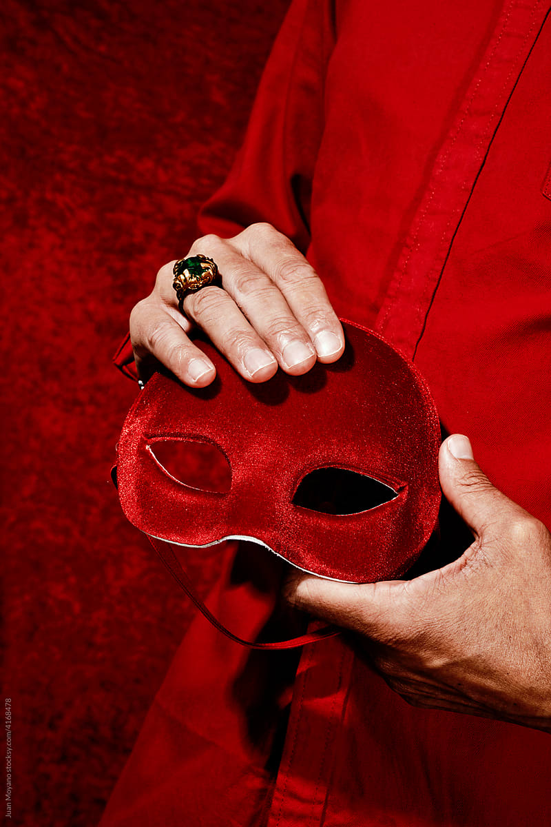 man holds a red mask