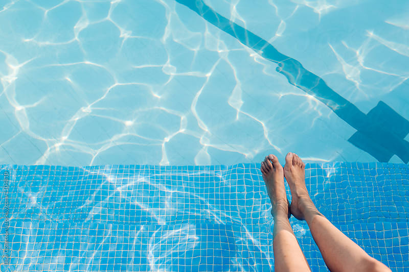 Woman feet in the pool