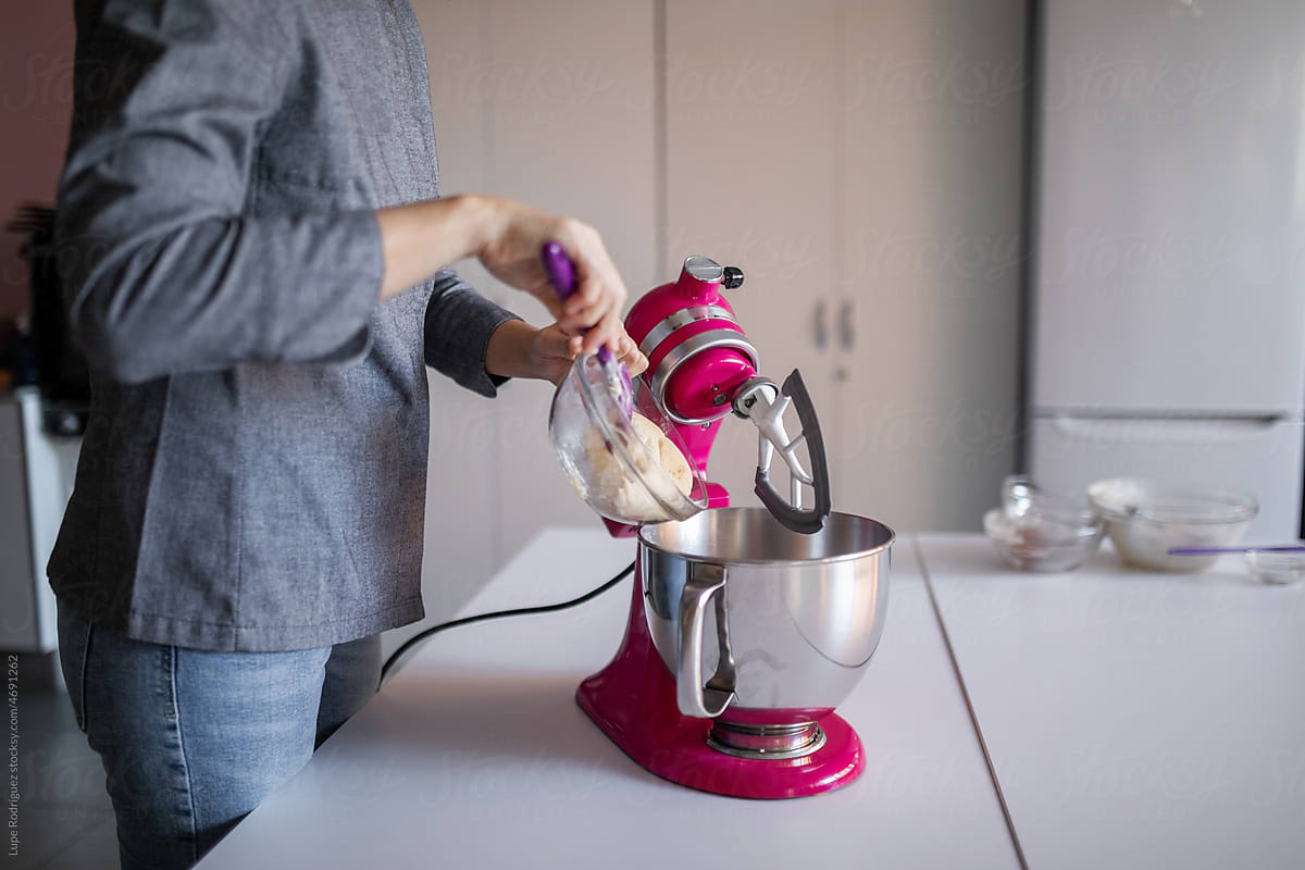 anonymous woman using a mixer in the kitchen of her business