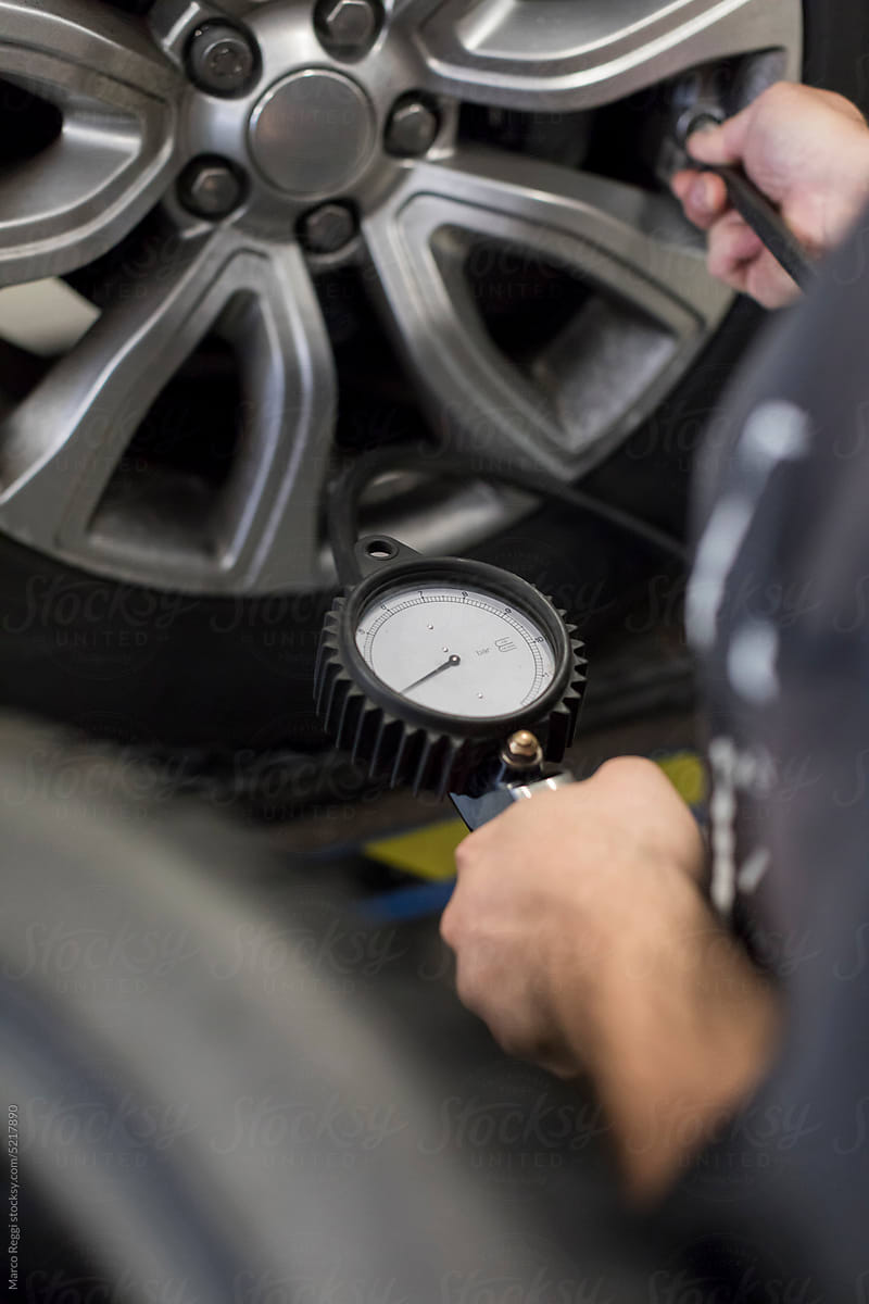 tire mechanic checks the wheels pressure