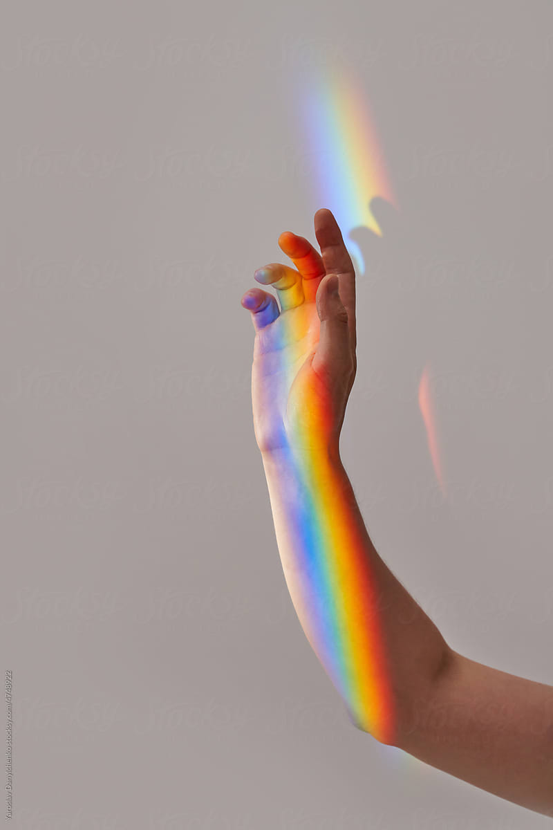 Rainbow effect over person\'s hand.