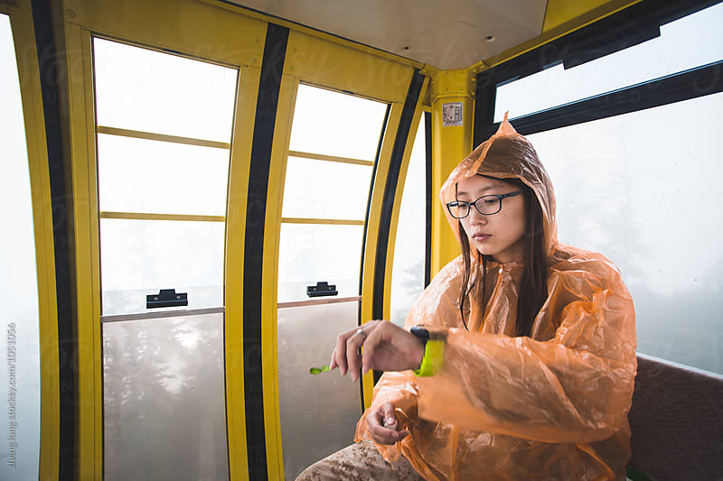 young girl wearing plastic raincoat in the funicular