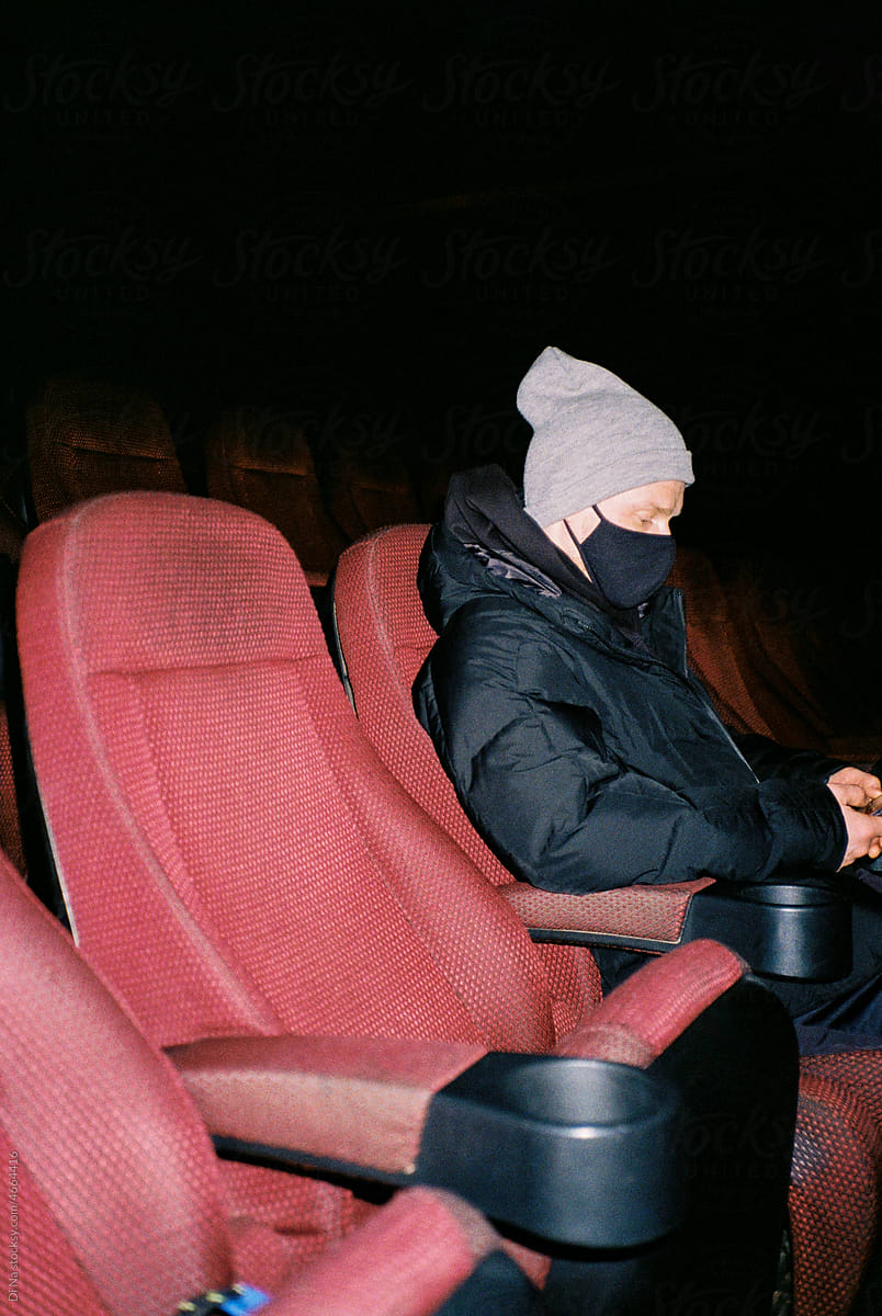 Young man in mask in cinema
