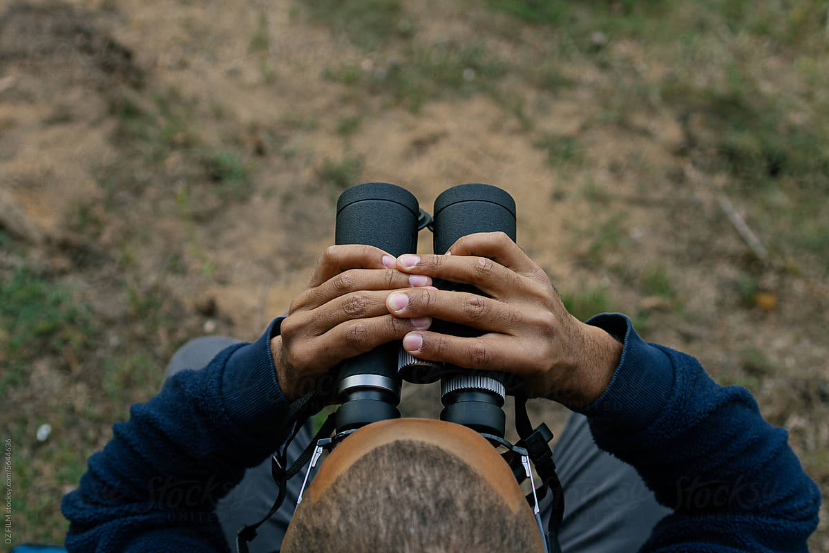 A man looks through binoculars