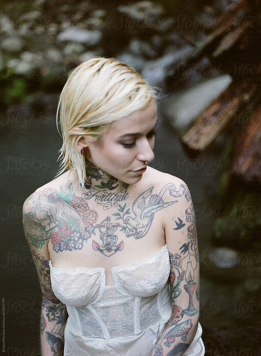 Tattooed Blonde woman soaking in Hotsprings Wearing White Lingerie
