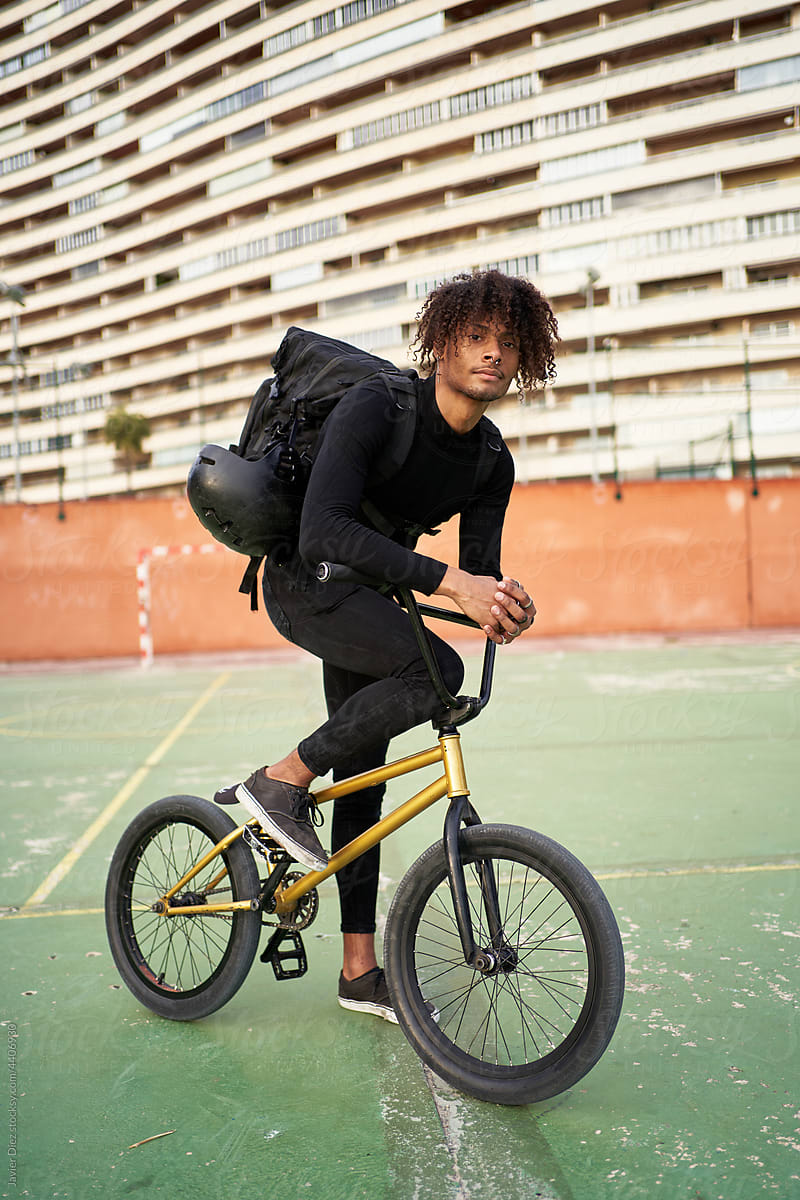 Young man on BMX bike on sports ground