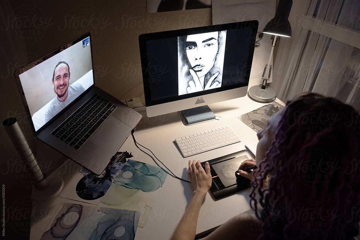 Female artist speaking with online friend while drawing