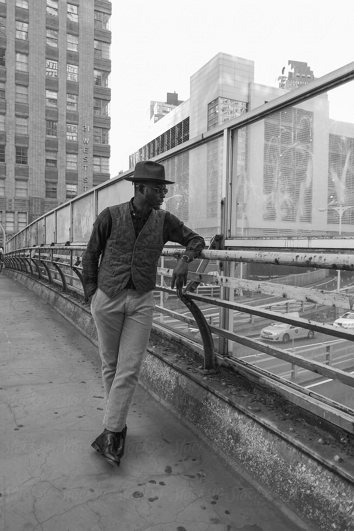 Young stylish man looking over a bridge