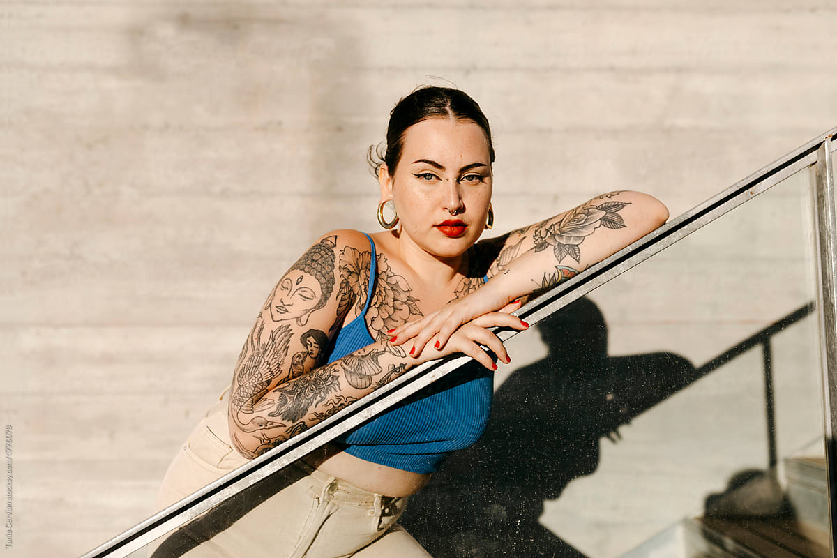 Curvy Tattooed Woman Leaning On Railing In City by Stocksy Contributor  Tania Cervian - Stocksy