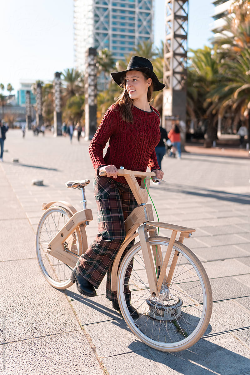 Happy woman with eco bicycle on street