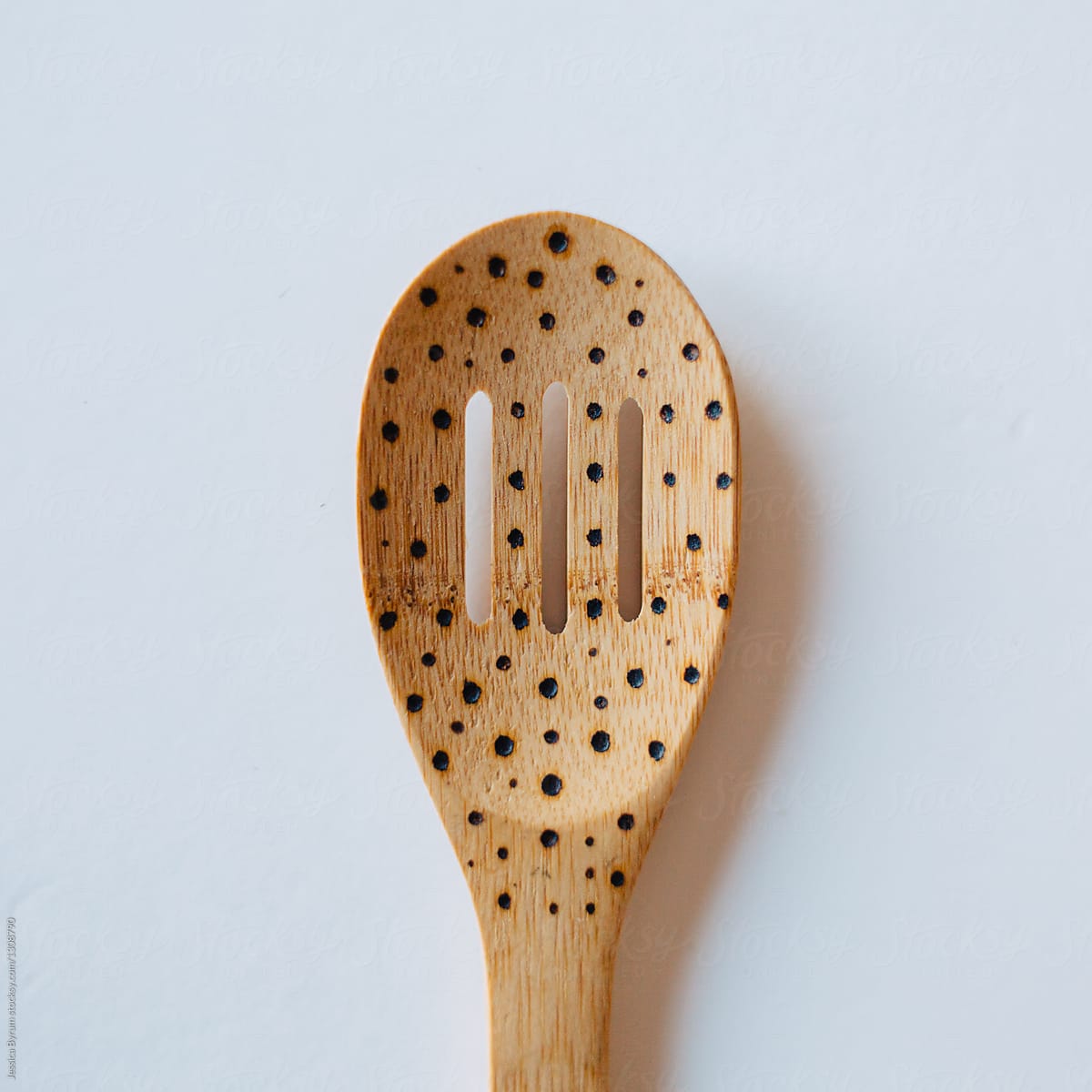 Wood burned bamboo wooden spoons on white background.