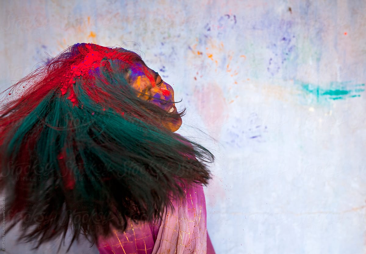 A Girl shaking head making fun with spray color powder