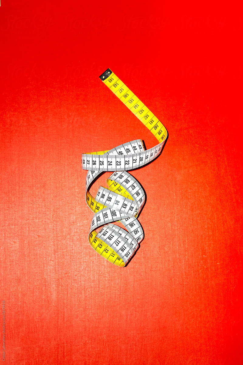 Measurement tape with hard direct flashlight on a coloured background