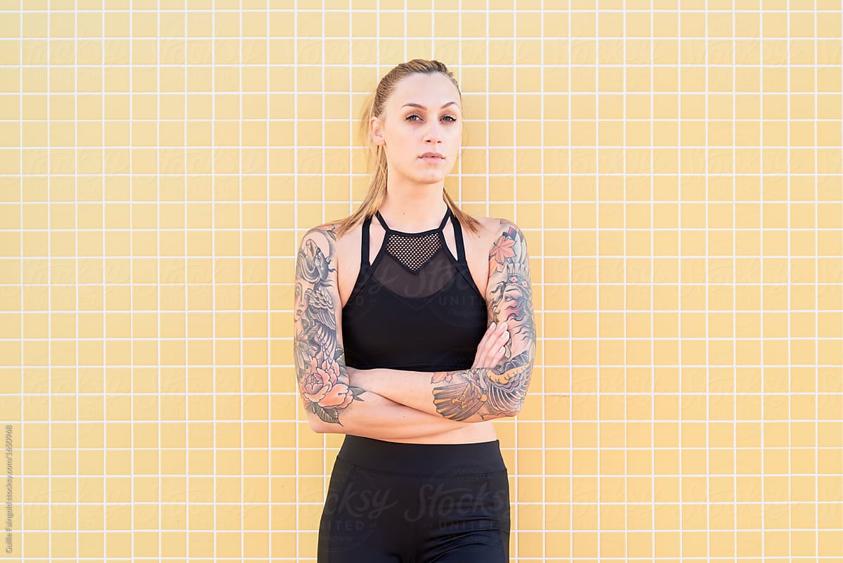 Sportswoman with tattooed arms in sportswear.