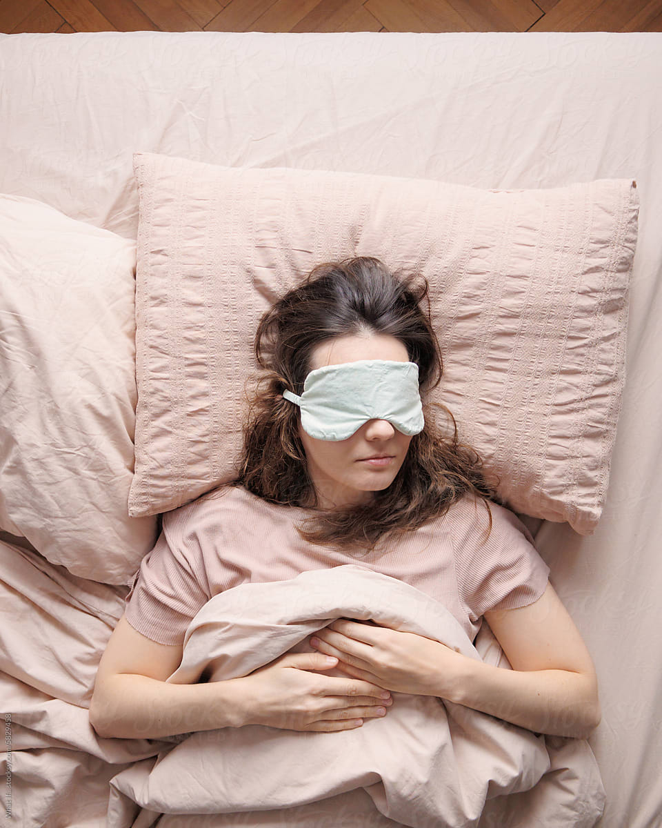 Top view of the person sleeps alone in bed in  sleep mask.