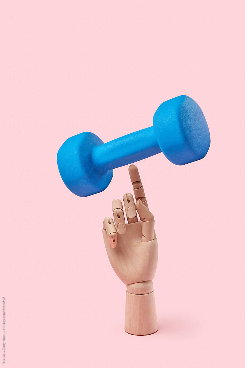 Balancing dumbbell on a wooden hand.