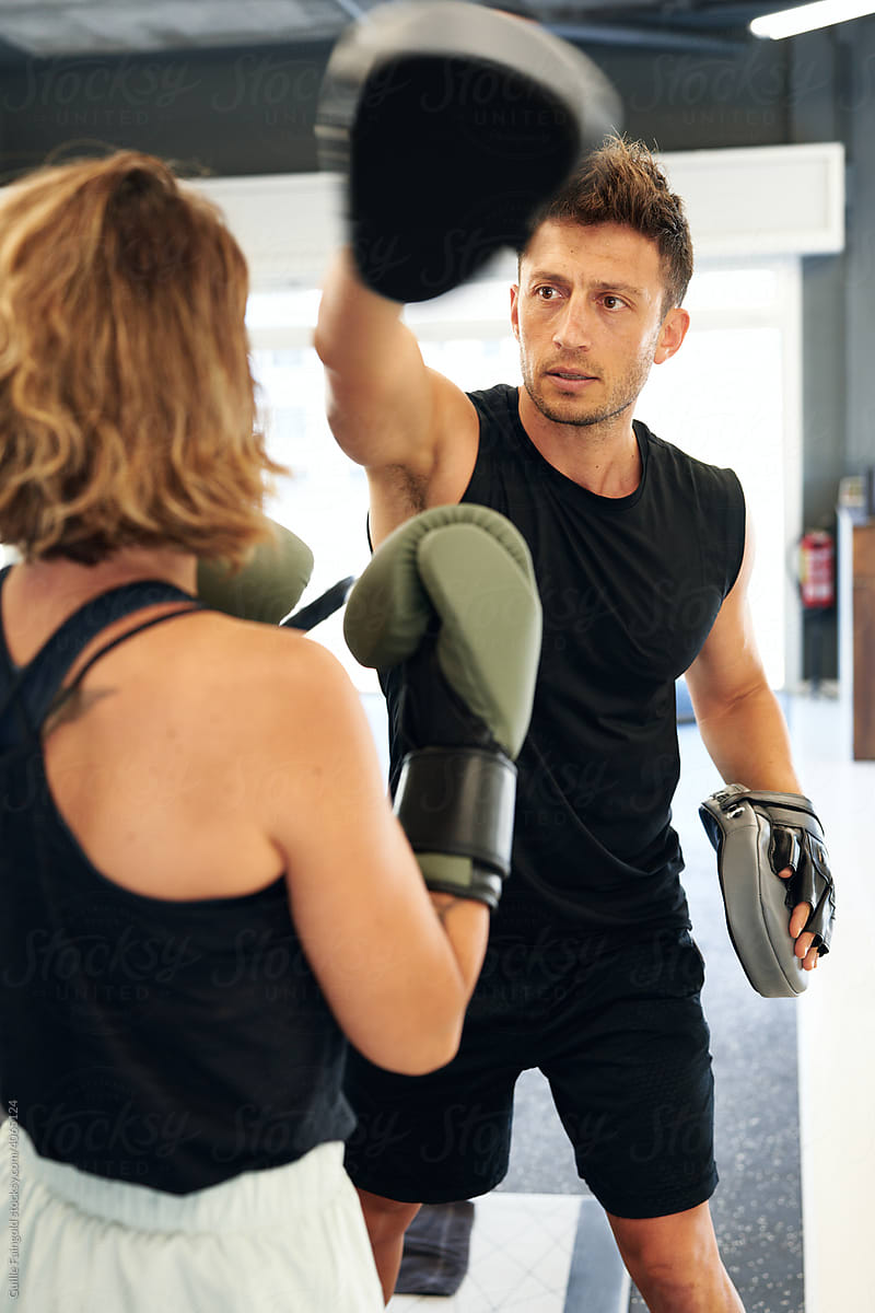Personal trainer and sportswoman during boxing workout