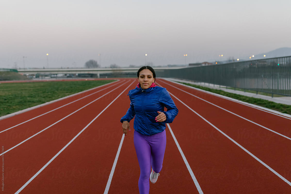 Woman Running On Track Field