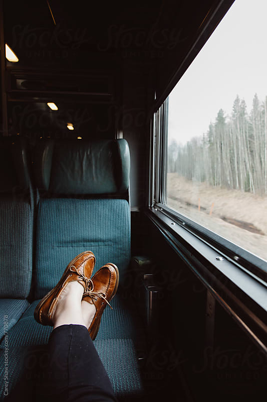 Feet resting on train seat