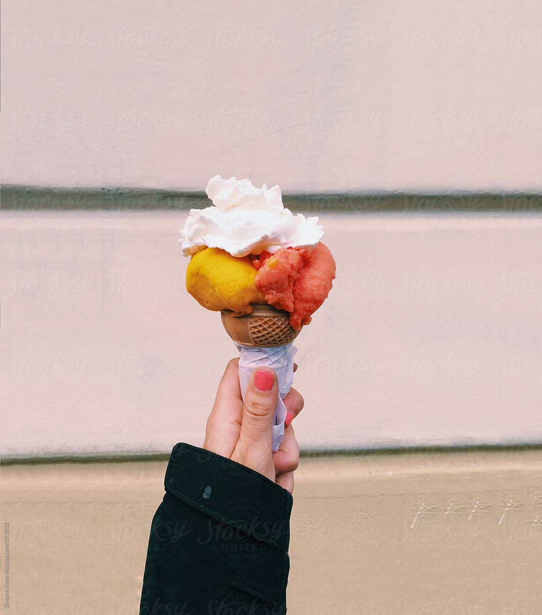 Woman holds gelato with cream on top