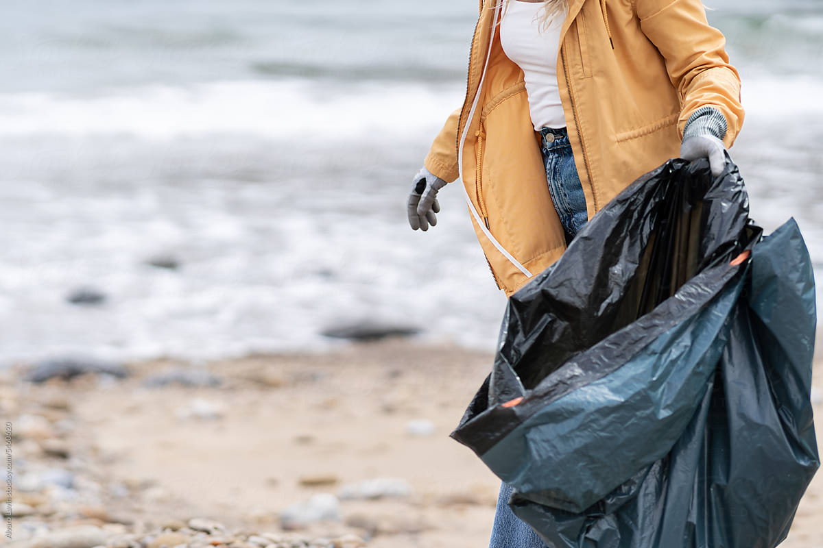 Volunteer picking up trash at beach.