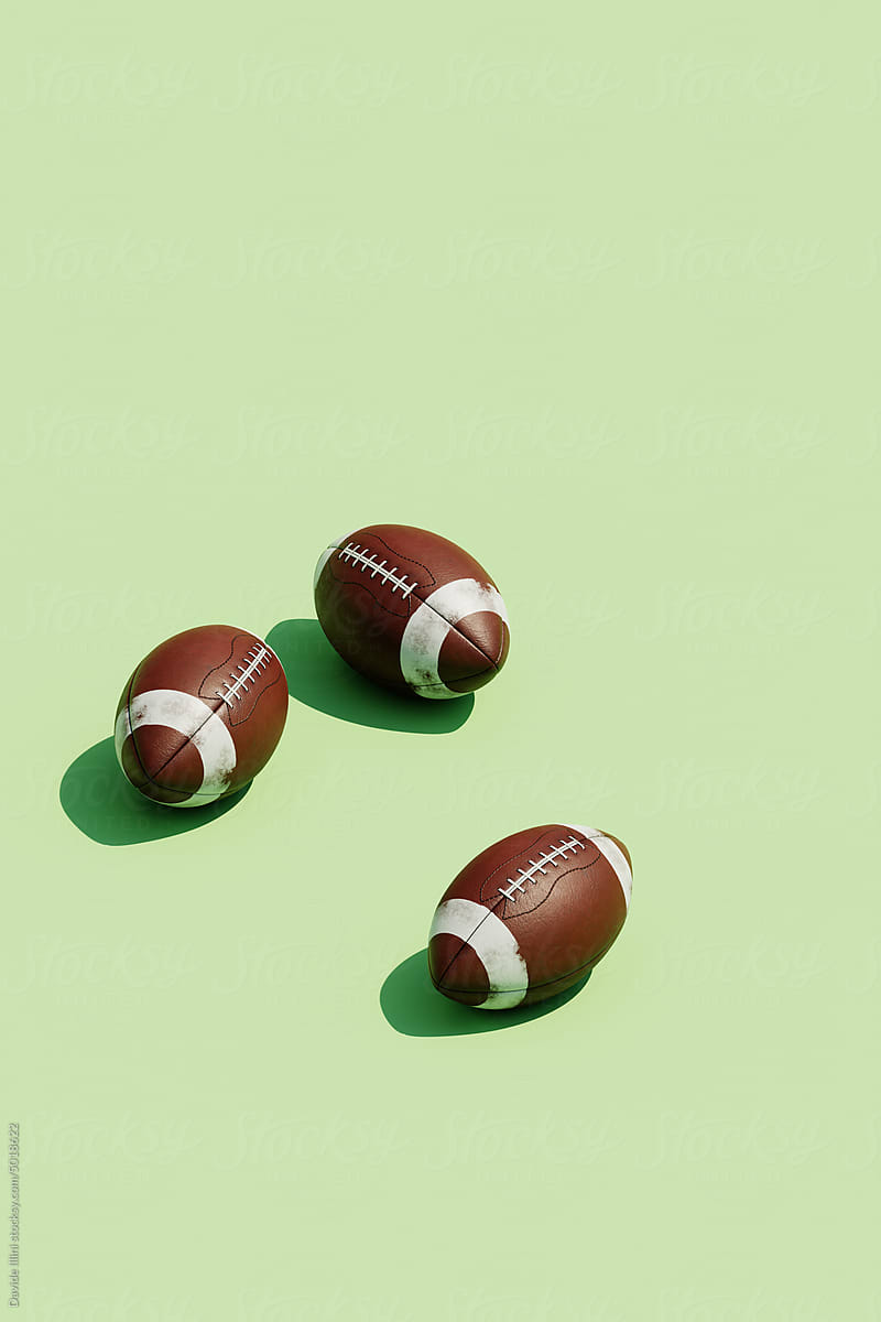 3d Rendering of several oval American football ball on a green.