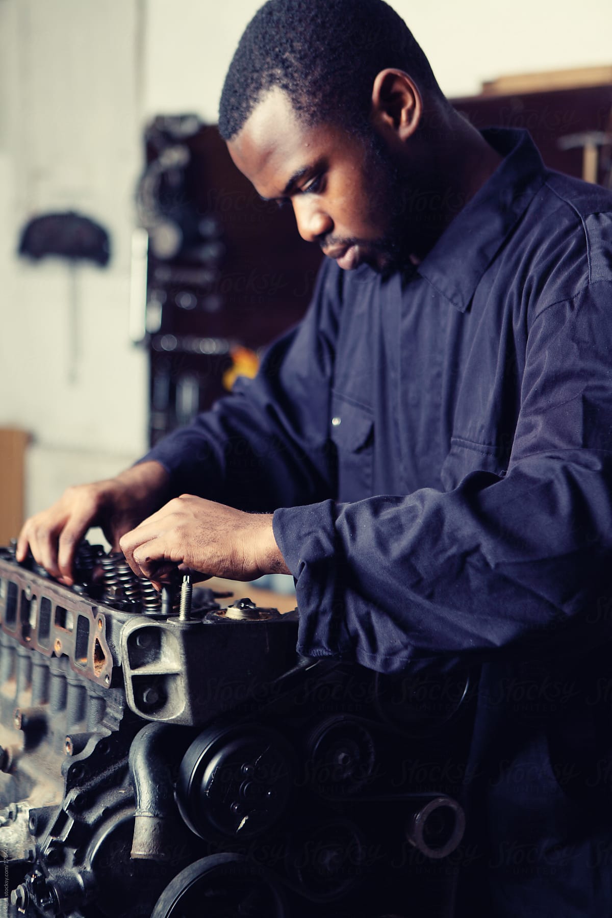 Young mechanic working on engine