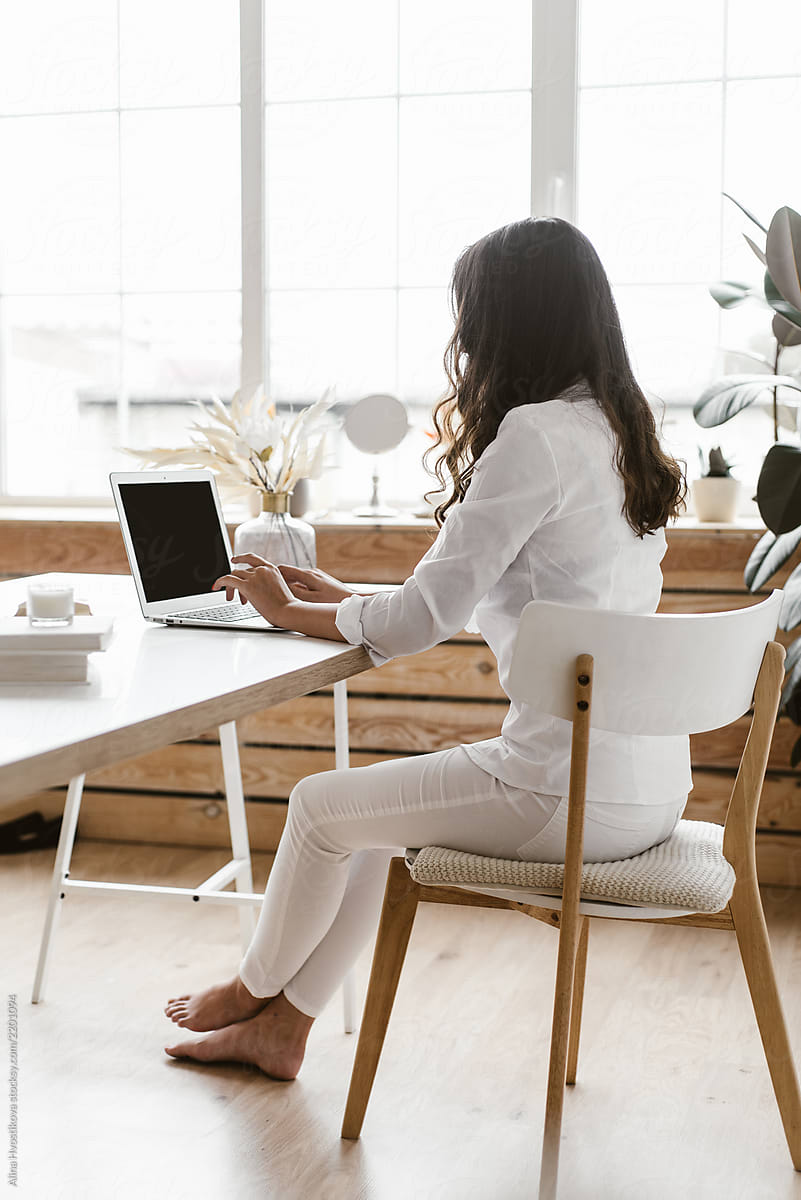 Woman Sitting At Desk With Laptop by Stocksy Contributor Alina