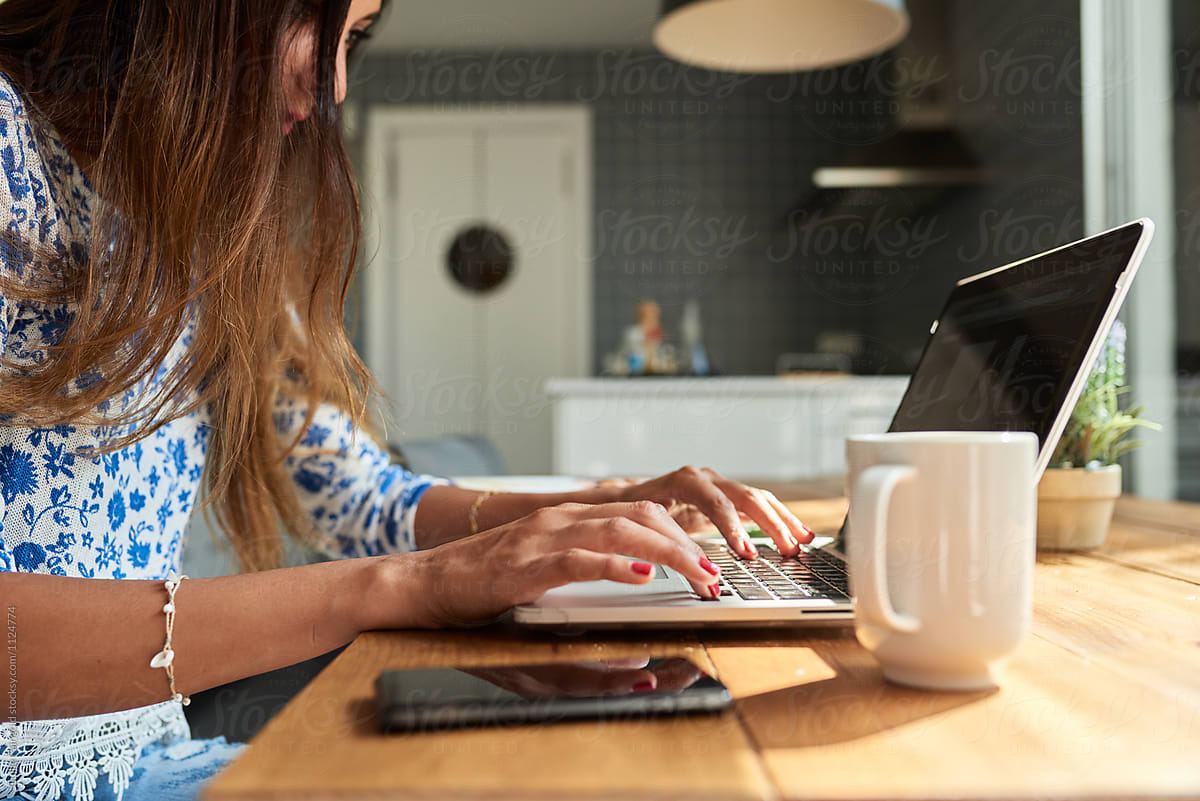 Woman Working On Laptop At Kitchen By Stocksy Contributor Guille Faingold Stocksy 2072