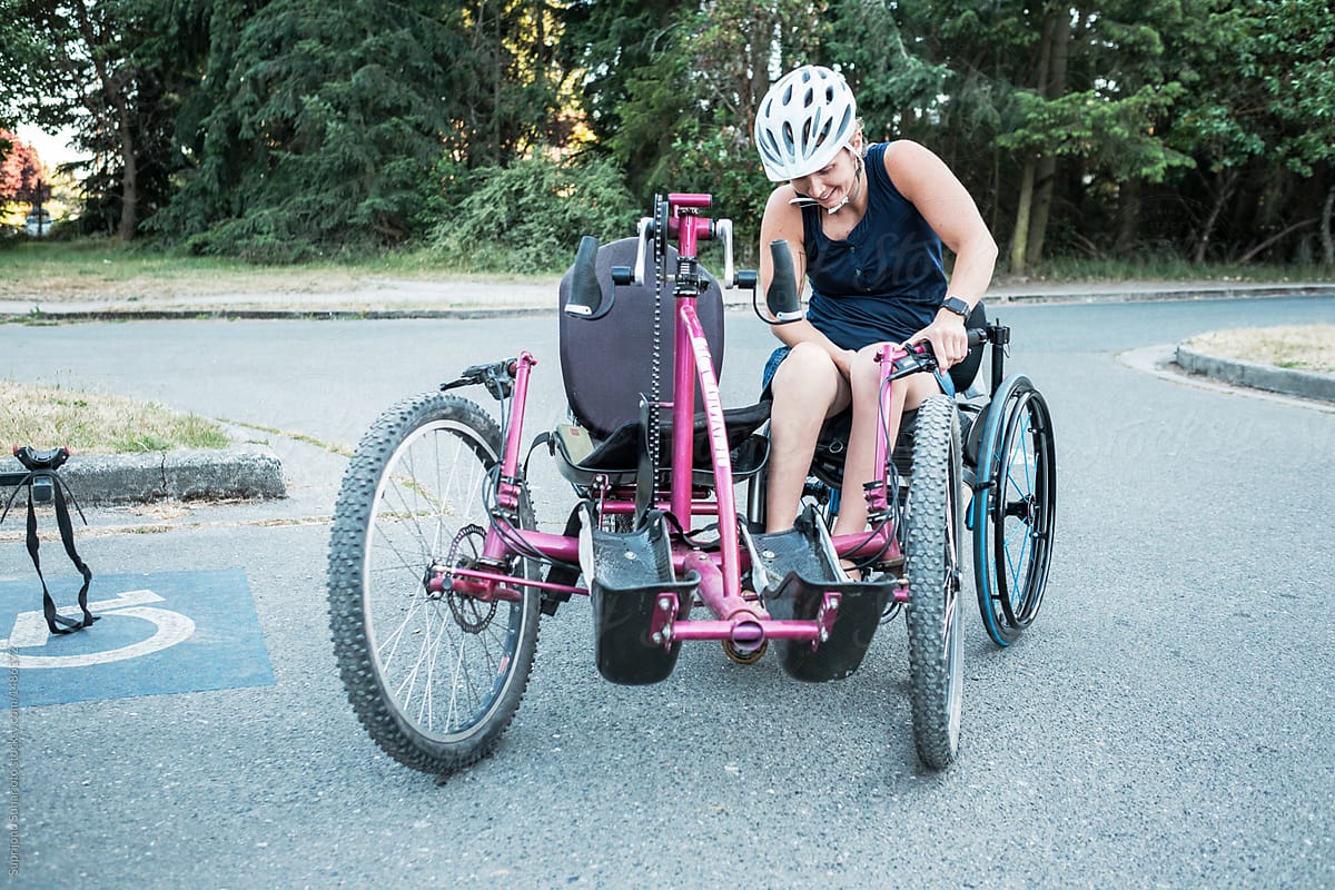 Disabled Active Woman Moving From Bicycle to Wheelchair