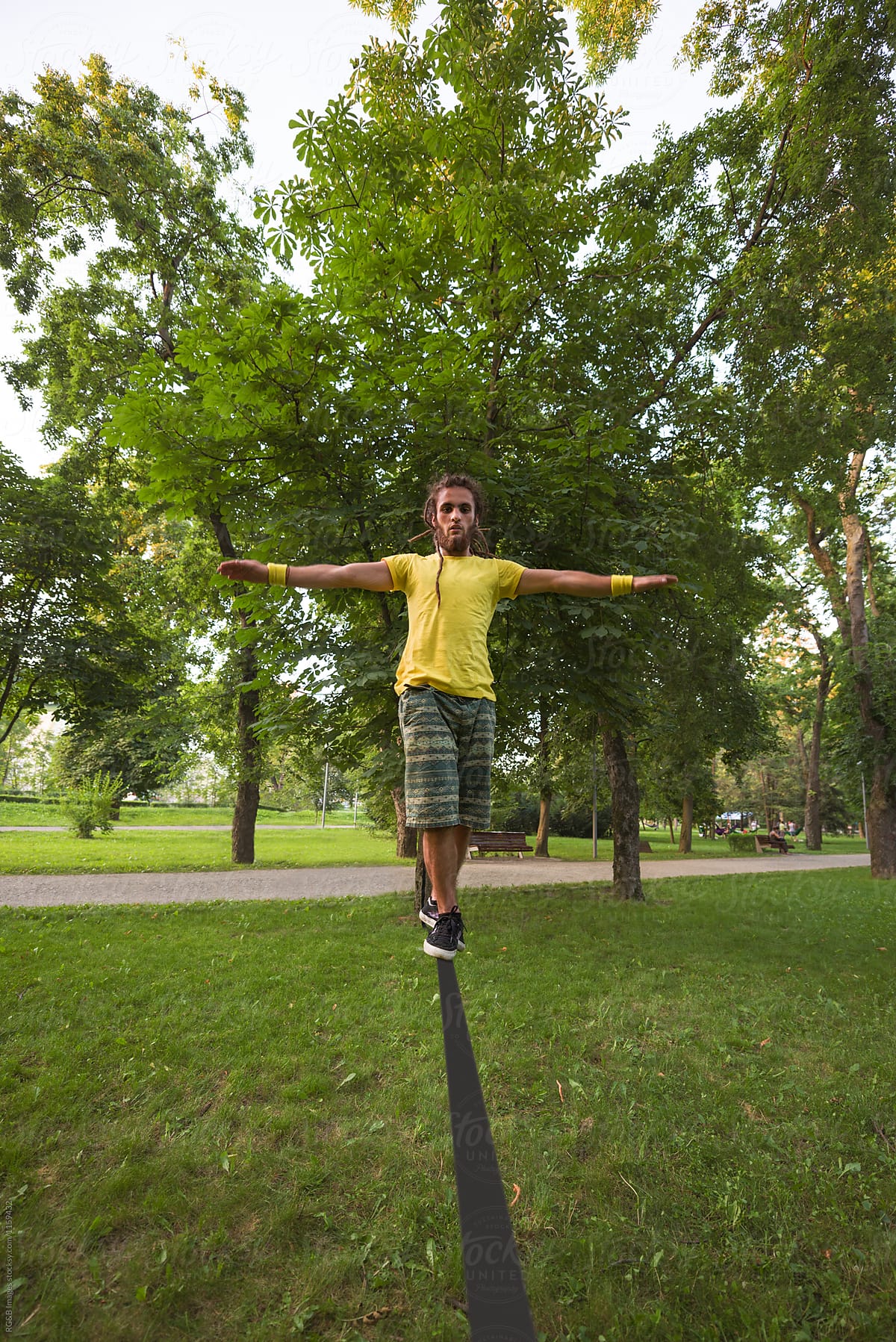 Man standing in balance on a narrow tightrope in the park