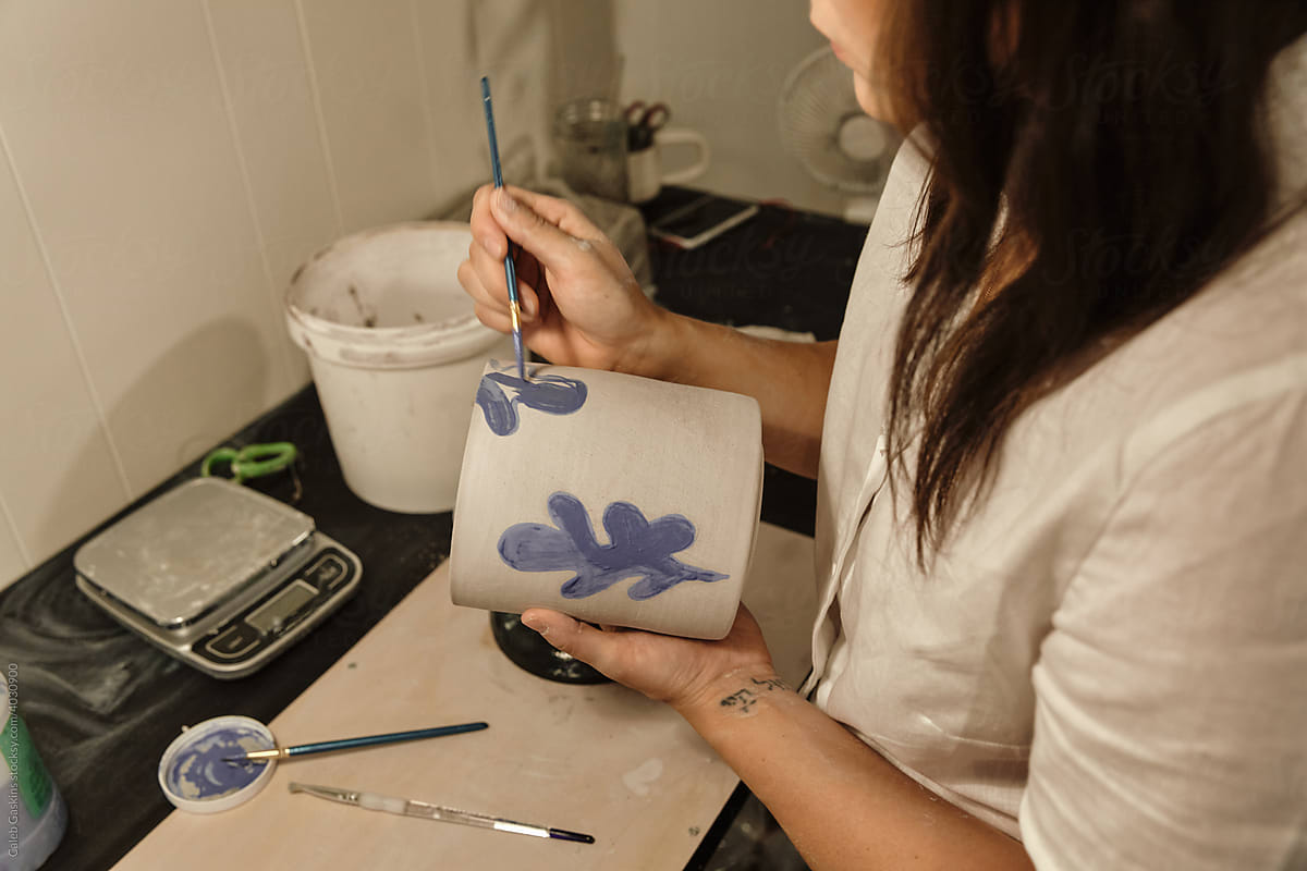Woman painting pottery