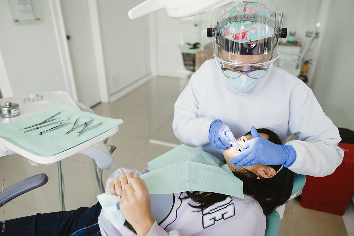 female dentist examining child teeth in dentist\'s office