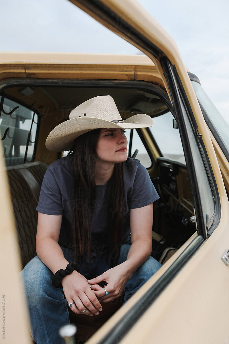 cowgirl sitting in old pickup truck