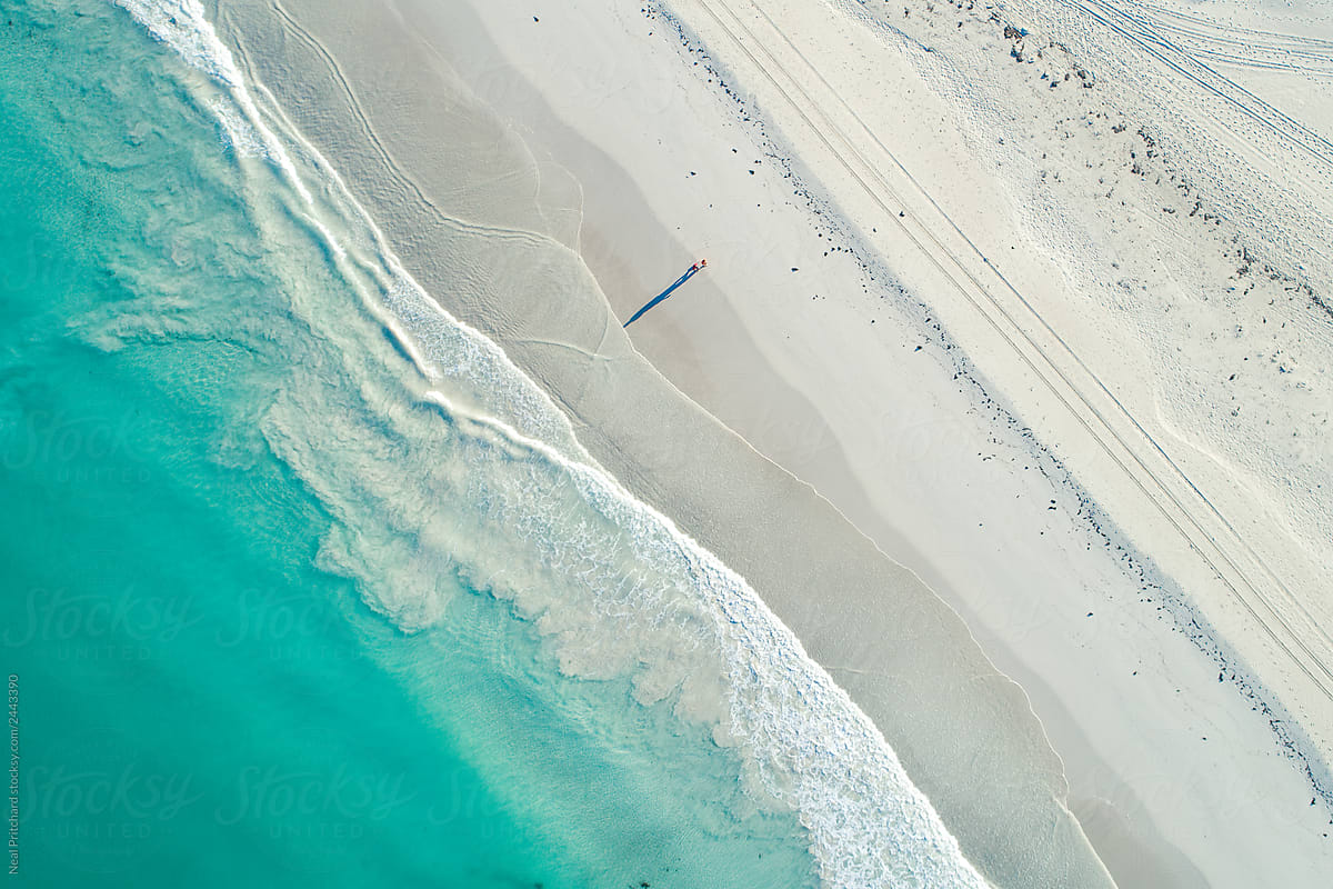 Aerial image of summertime beach scene of white sandy beach and clear clean turquoise waters