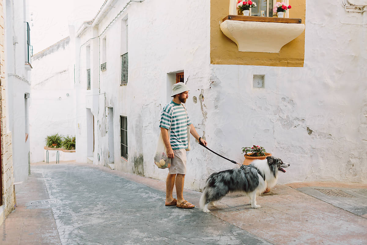 Man turning the corner with his dog