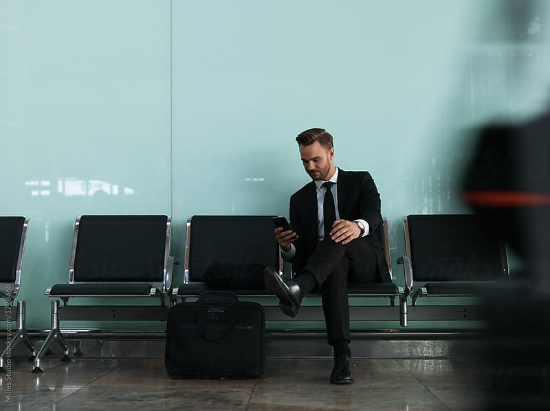 Man in black with smartphone in airport