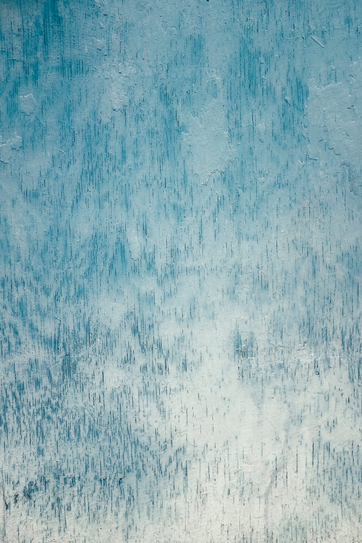 Close up of blue and turquoise paint covering graffiti on plywood wall