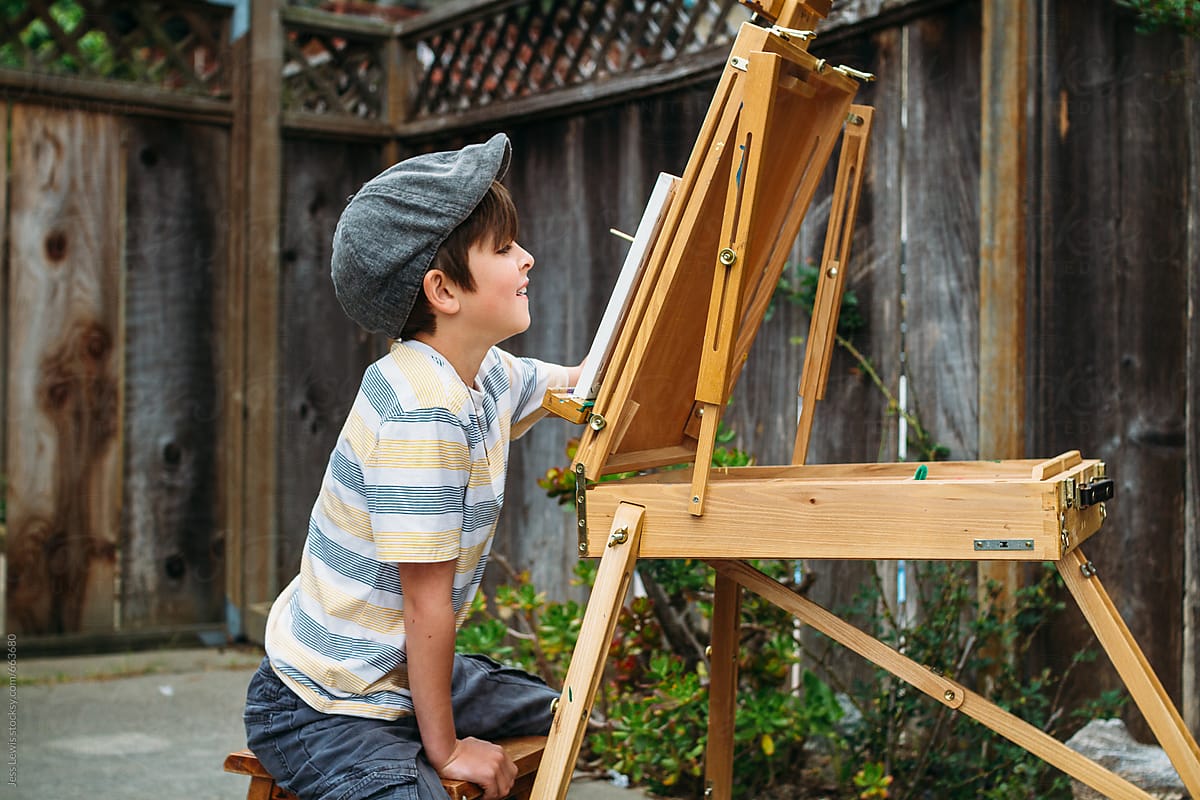 happy boy painting at an easel