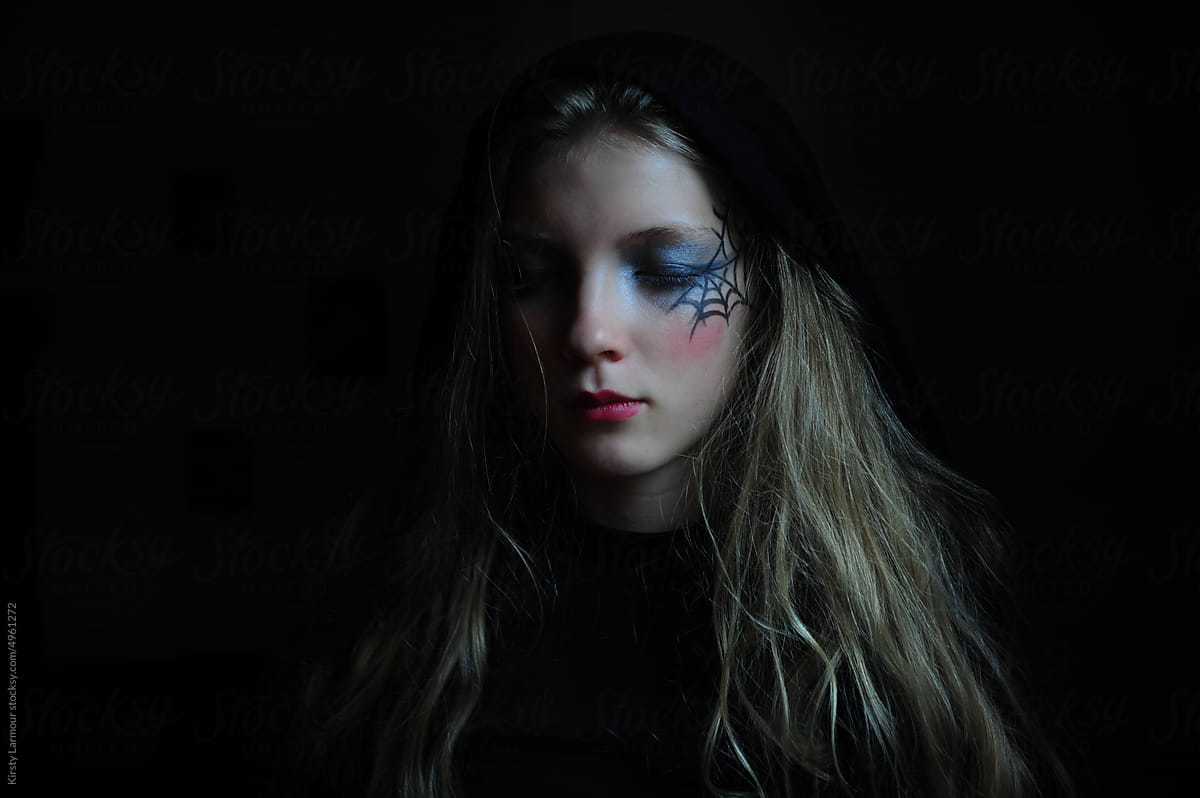A girl dressed up with creepy doll/ spiders web make up for Halloween