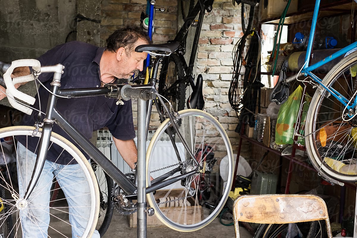 Man Repairing a Bike in a Garage