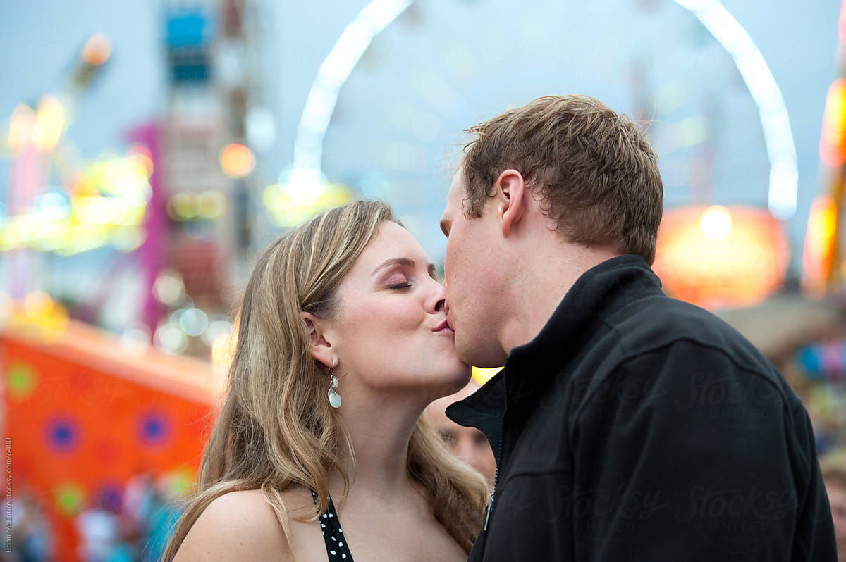 Couple Kissing with Carnival Ferris Wheel in Background