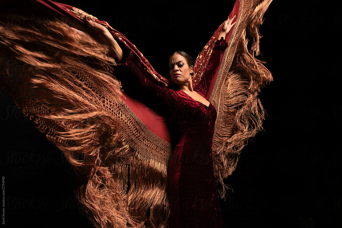 Young woman dancing flamenco on black
