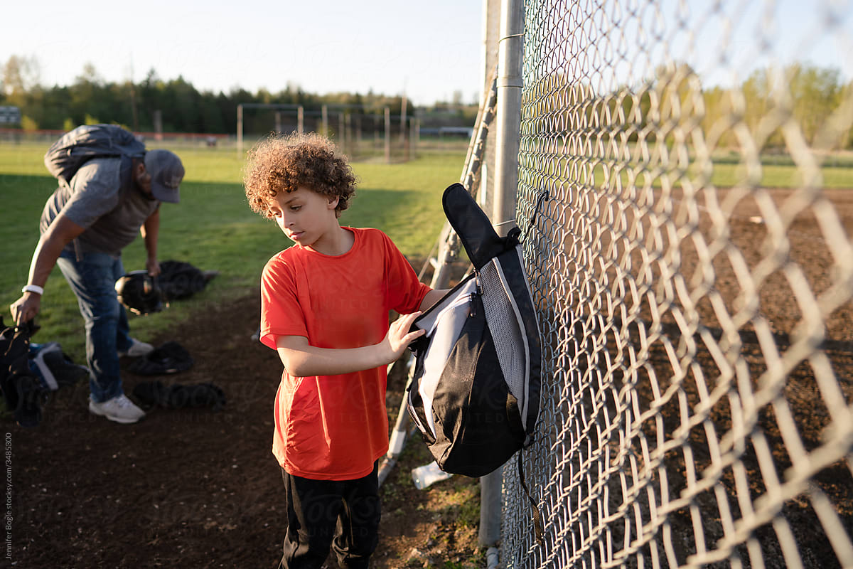 Boy loads gear at baseball field