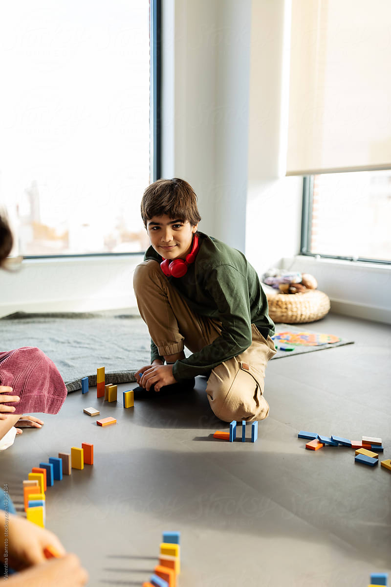 Boy with friends doing circuit with colorful dominoes