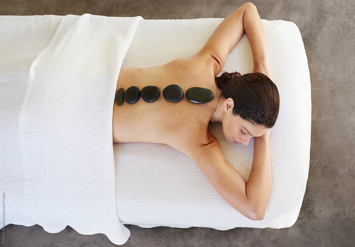 Woman receiving hot stone massage at luxury spa