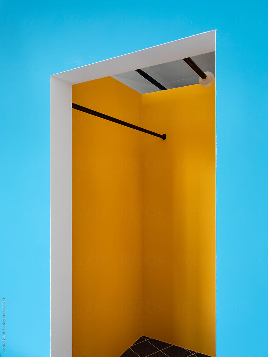 Yellow closet and coat rack in blue wall apartment