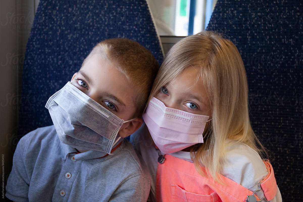 Kids on a train wearing masks.